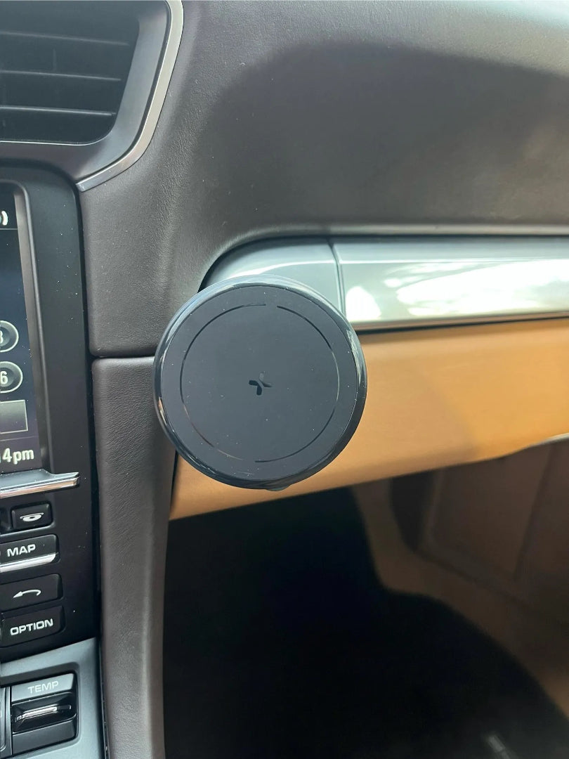 Interior view of a car dashboard featuring a black circular magnetic phone holder