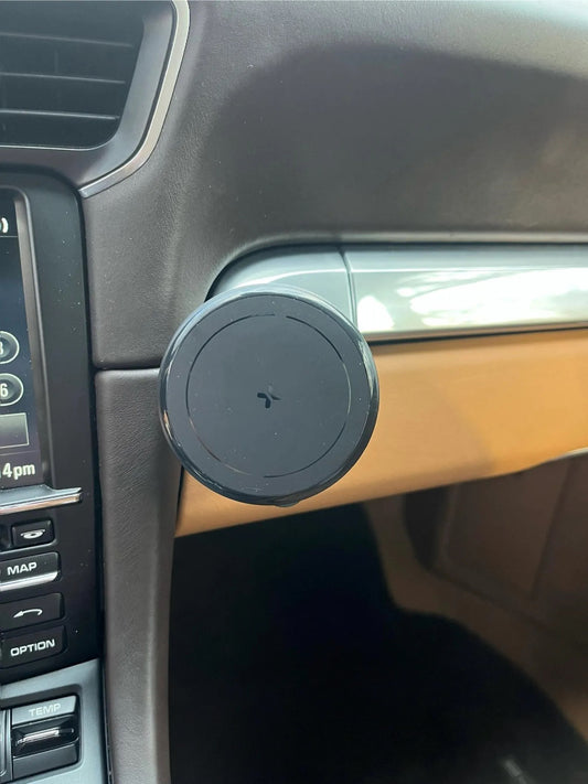 Interior view of a car dashboard featuring a black circular magnetic phone holder
